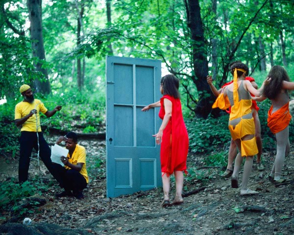 The Woman in Red goes to the Black Male Artists’ door and the Debauchees dance back up the hill, performance Rivers First Draft by Lorraine O’Grady.
